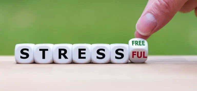 Finger turning dice to change 'Stressful' to 'Stress Free' symbolizing stress relief and mental well-being