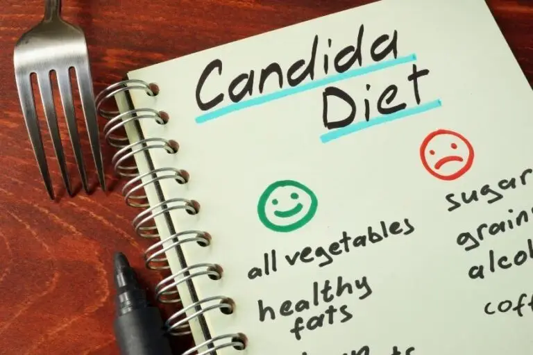 A notebook with 'Candida Diet' written on it, listing good and bad foods for Candida overgrowth. A fork and pen sit nearby, symbolizing dietary choices.